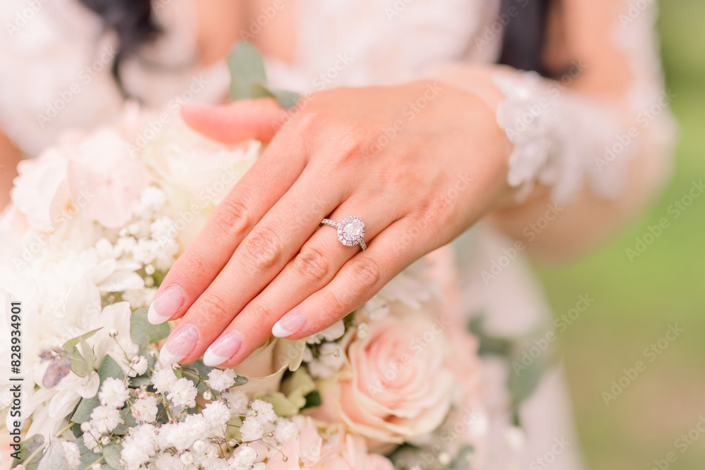 A bride is married and shows her engagement ring over her soft bridal flowers. She wears a lace outfit. A bride is married and shows her engagement ring over her soft bridal flowers. She wears a lace outfit.