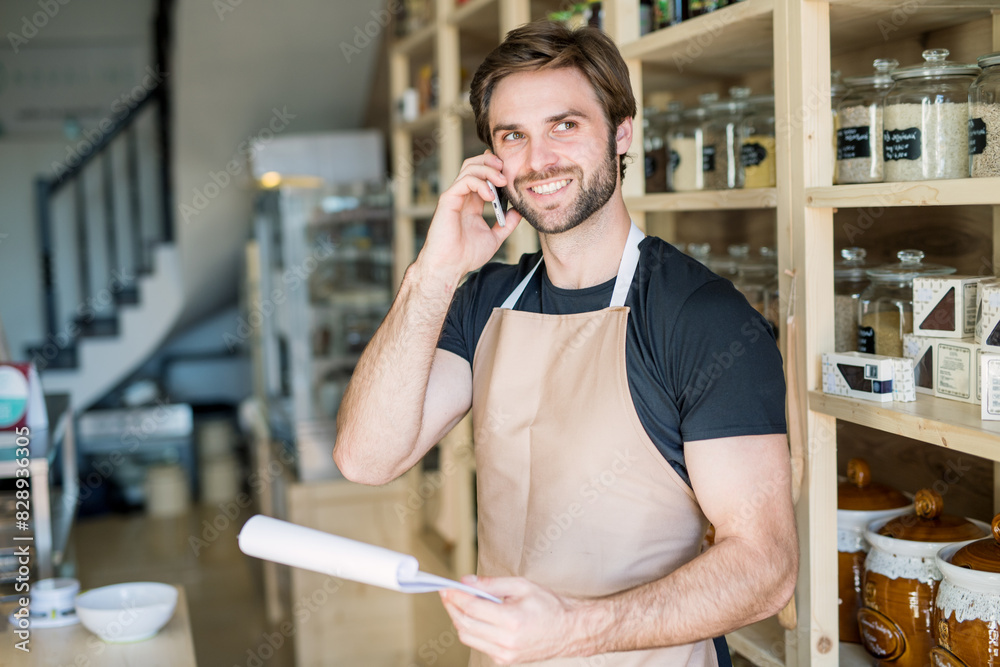 Handsome man working in package-free store using reusable containers. Zero waste shops offering package-free bulk goods and sustainable alternatives. Handsome man working in package-free store using reusable containers. Zero waste shops offering package-free bulk goods and sustainable alternatives.