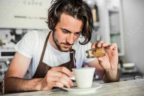 Fotografie Handsome barista working in coffee shop, preparing coffee