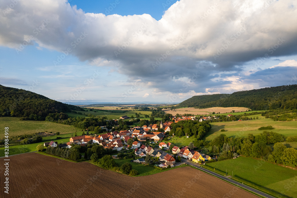 Aer ial view of a German village surrounded by meadows, farmland and forest. Thuringia, Germany.