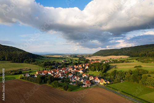 Aer ial view of a German village surrounded by meadows, farmland and forest. Thuringia, Germany. photo