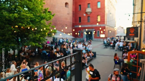 In a lively city, people dine at an outdoor cafe, socializing and relaxing in a festive atmosphere