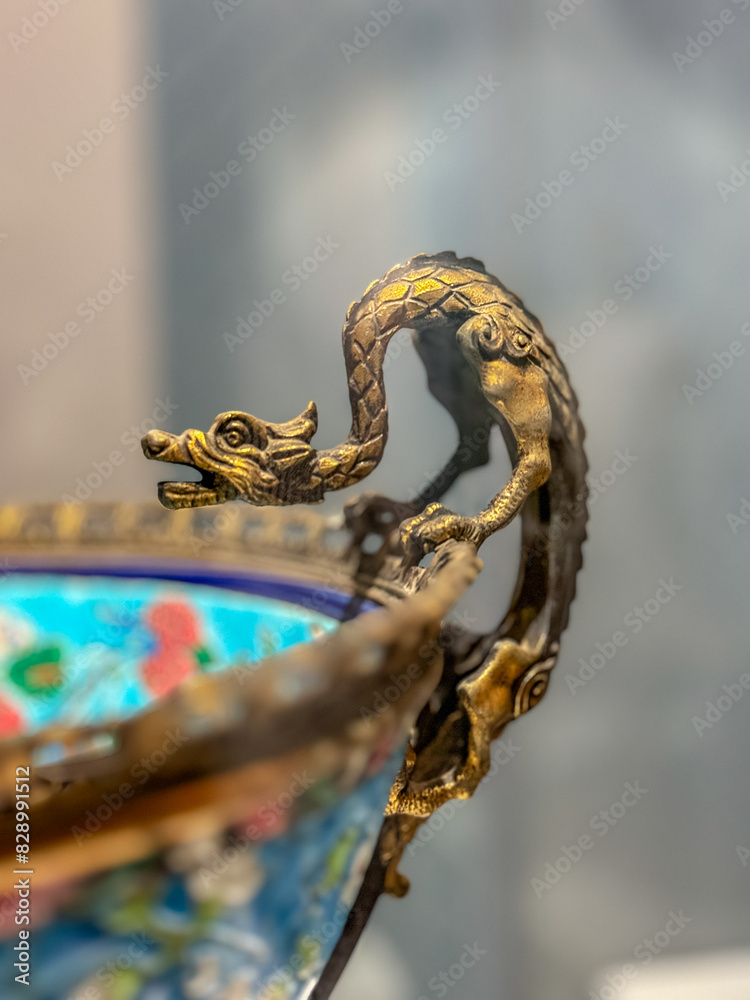Obraz premium A metal dragon on the edge of the bowl.