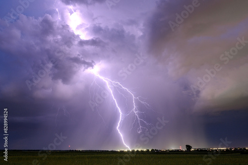 A huge storm cloud with a wall of rain in the countryside.	