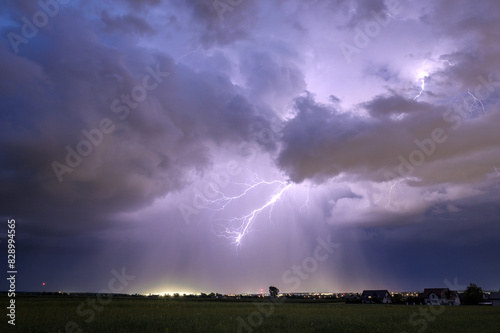 A huge storm cloud with a wall of rain in the countryside.	