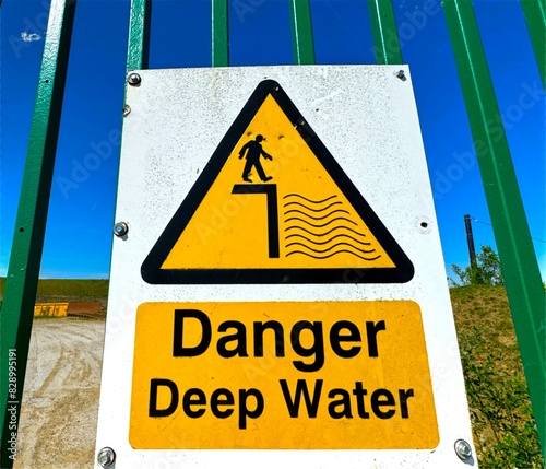 A yellow warning sign reading 'Danger Deep Water' stands on the hills high above Haslingden, Lancashire, UK.