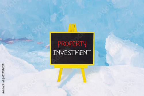 Property investment symbol. Concept words Property investment on beautiful yellow blackboard. Beautiful blue ice background. Business Property investment concept. Copy space.