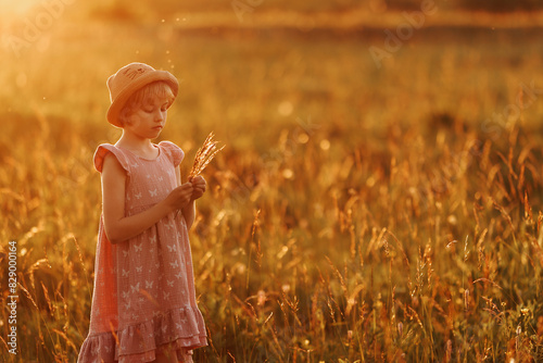 A young girl in a field of flowers, holding a bouquet of spikelets. The scene is peaceful and serene, with the girl enjoying the beauty of nature