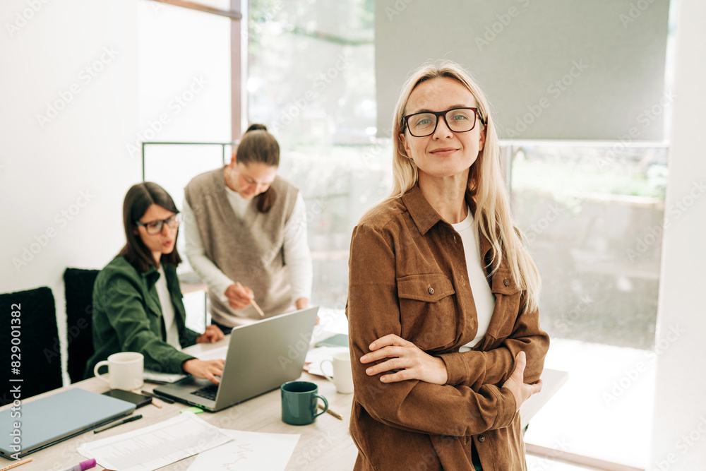 © Ilona - Portrait of a modern attractive blonde cosmopolitan business woman in the office.