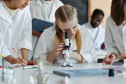 Wallpaper Mural Selective focus shot of Caucasian girl using microscope while doing chemical experiment with classmates during lesson Torontodigital.ca