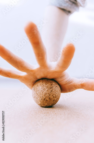 Close up of hand doing palm fascia release exercise with cork ball