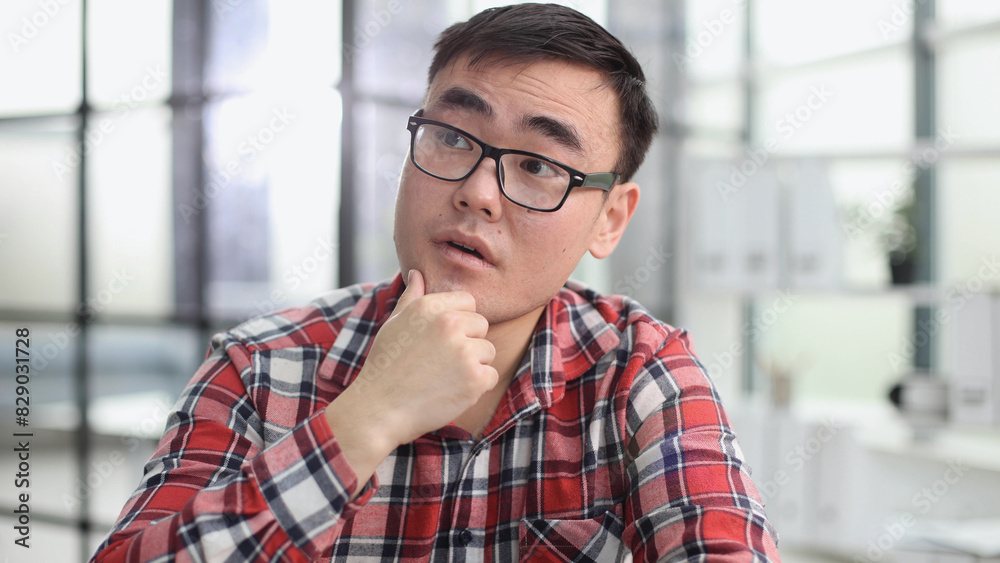 Obraz premium a young investor in casual clothes sits at a table and thinks about profit