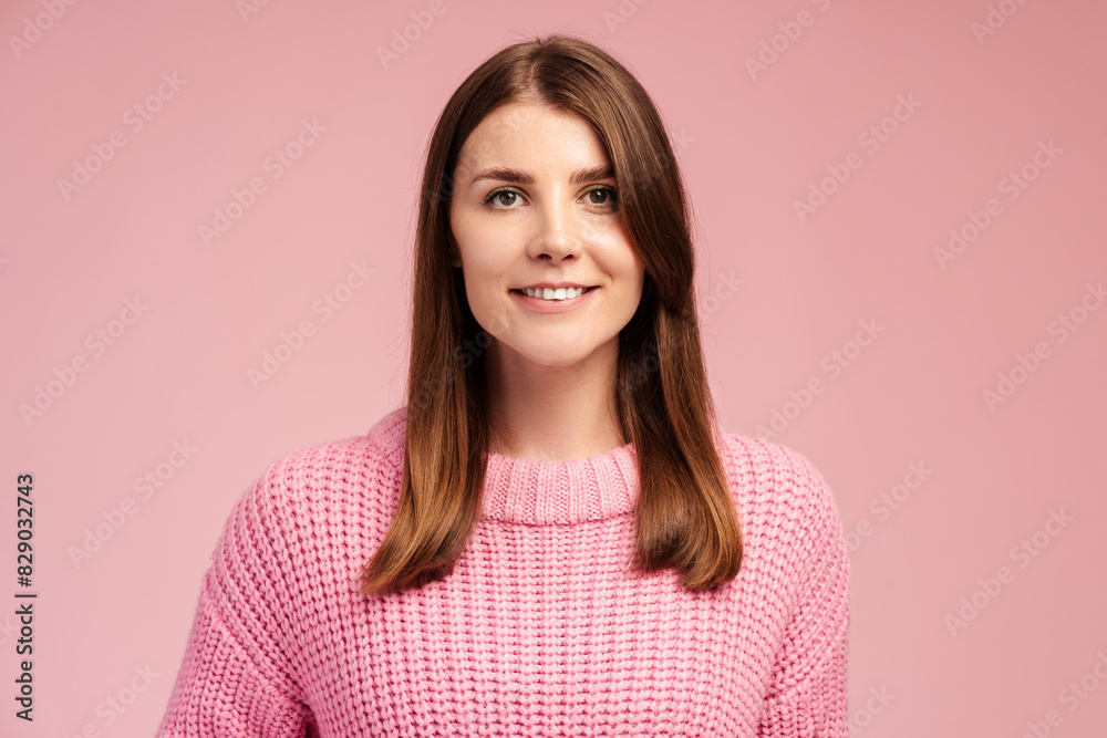 Attractive, smiling middle aged woman wearing pink sweater looking at camera Attractive, smiling middle aged woman wearing pink sweater looking at camera