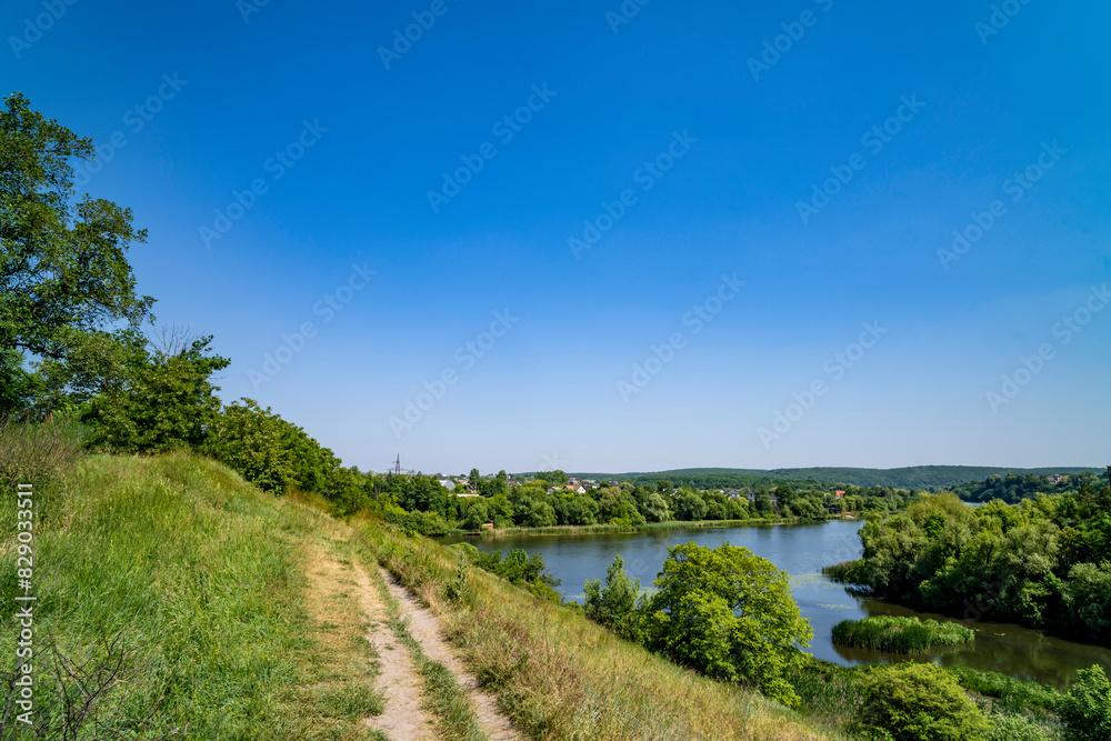 Spring river, grass, bushes, trees. Nature landscape.