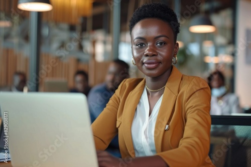 Confident African businesswoman working with colleagues at office table.