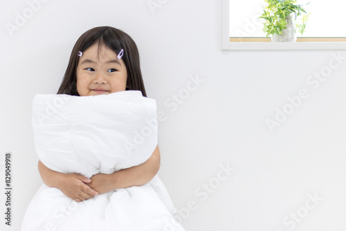 Obraz na płótnie 布団を持つ笑顔の女の子(3歳、日本人) w salonie