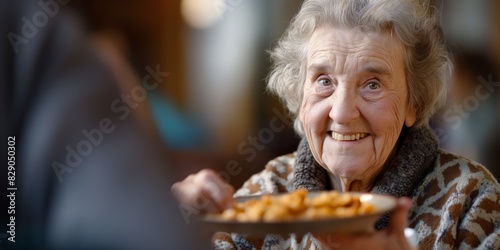 An elderly woman with a joyful expression is being served a plate of food