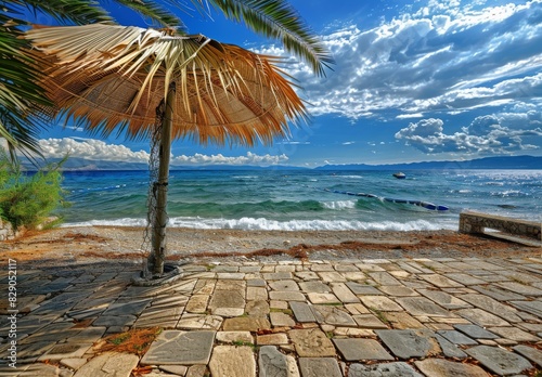 Summer beach: Paralia, Olympic Riviera, Pieria, Greece. Palm parasol shades the sand. photo