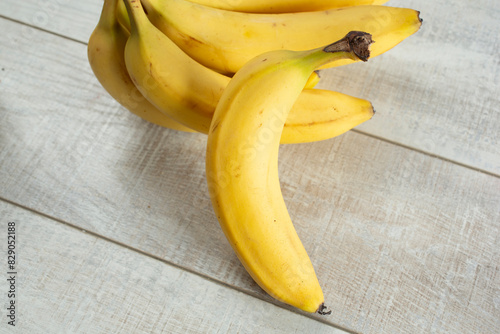 A view of a banana leaning against a banana bunch. photo