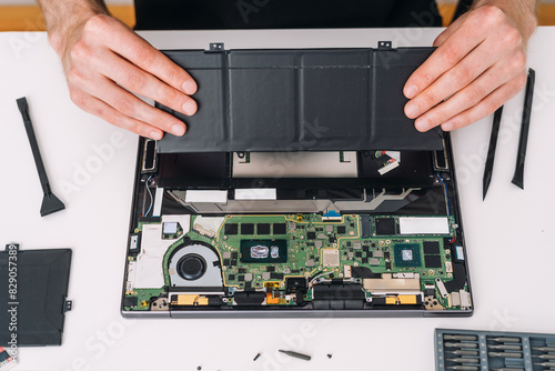 Bild auf Leinwand Service technician remove, recycle and replace old battery on laptop