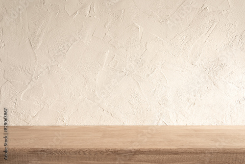Billede på lærred A clean, minimalist wooden kitchen counter against a textured off-white wall in a bright daytime setting