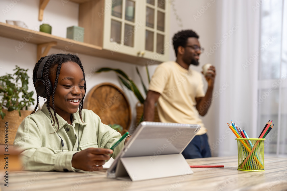 Obraz premium Black little girl taking class online using digital tablet