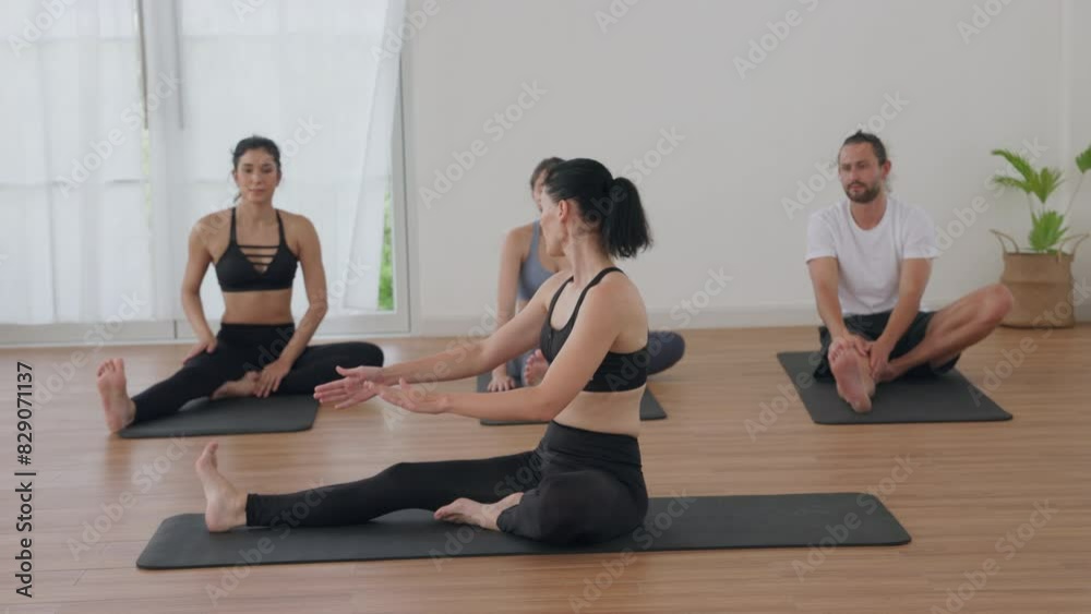 Group Yoga Class in a Bright Studio with Instructor Giving Guidance Group Yoga Class in a Bright Studio with Instructor Giving Guidance