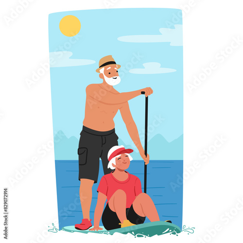 Senior Couple Enjoy A Sunny Day Paddleboarding. Elderly Man Standing And Paddling While The Woman Sits Contentedly