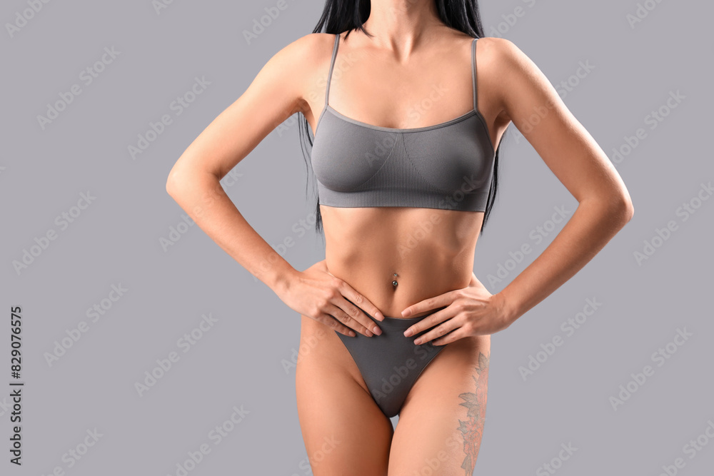 Beautiful young woman in grey underwear on light background Beautiful young woman in grey underwear on light background