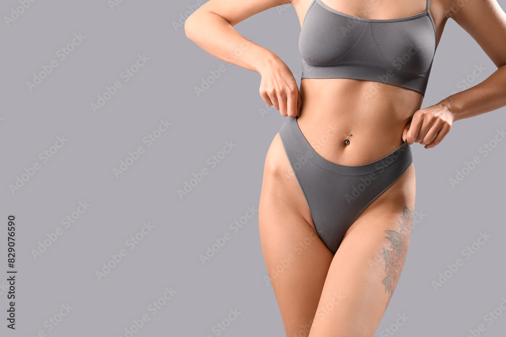 Beautiful young woman in grey underwear on light background Beautiful young woman in grey underwear on light background