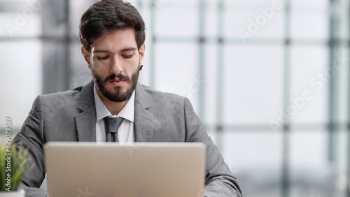 Successful businessman working inside office, man in business suit working at workplace with documents and laptop