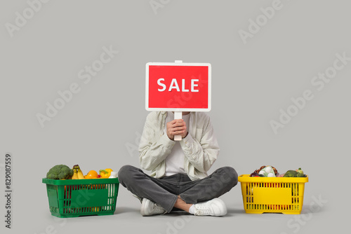 Young man with SALE sign an...