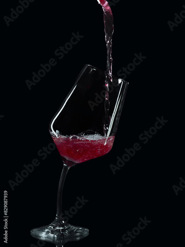 Red wine being poured into a leaning wine glass with a crooked stem