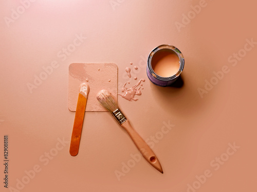 Peach paint colour text with a paint pot, paintbrush and paint sample photo