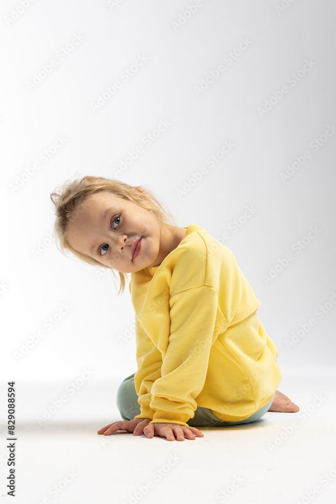 Portrait of beautiful cute little toddler girl. Child with funny face in yellow sweatshirt. Pretty smile kid in studio on white background. High quality photo Portrait of beautiful cute little toddler girl. Child with funny face in yellow sweatshirt. Pretty smile kid in studio on white background. High quality photo