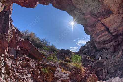 Sunburst in a blue sky over Cliff cave below Crystal Mesa, Petrified Forest National Park, Arizona, USA photo