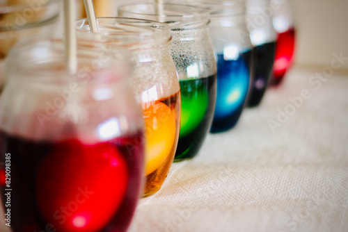 Close-up of a row of glass jars filled with multi coloured dye for dying Easter Eggs