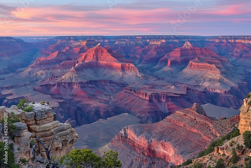 A stunning panoramic view of the Grand Canyon at sunrise, showcasing the vast expanse of the canyon and the colorful layers of rock formations