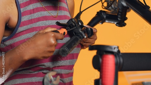 Close up shot of toolbox mechanical tools used by engineer to repair brake levers on bicycle handlebars, studio background. Woman utilizing screwdrivers and pliers to mend defective bike parts