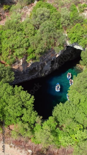 Famous Melissani lake on Kefalonia island, Karavomylos, Greece. Aerial view of the Melissani Cave lake in Karavomylos village on Cephalonia island , Greece. Zoom out drone footage photo