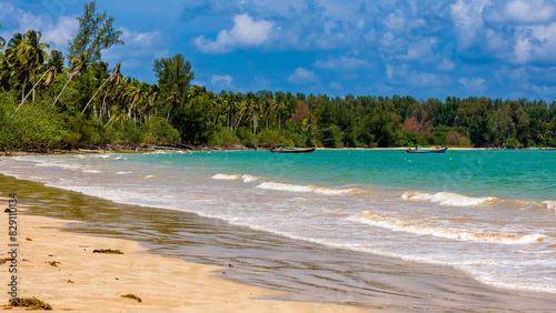 Small fishing boats anchored off a small, palm fringed tropical beach in Thailand photo