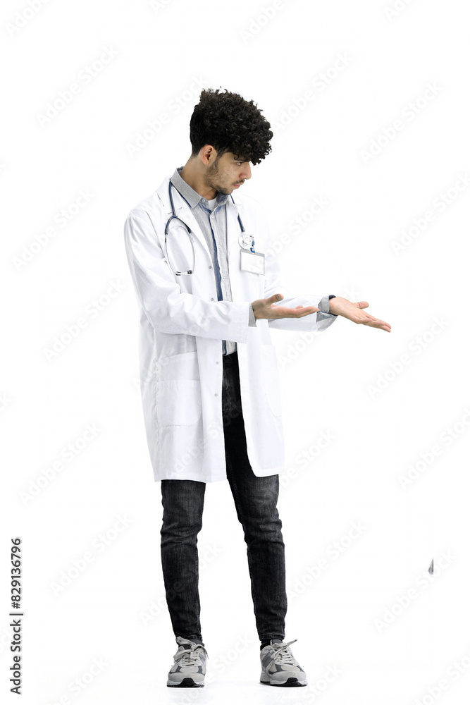 The male doctor, full-length, on a white background, points to the side The male doctor, full-length, on a white background, points to the side