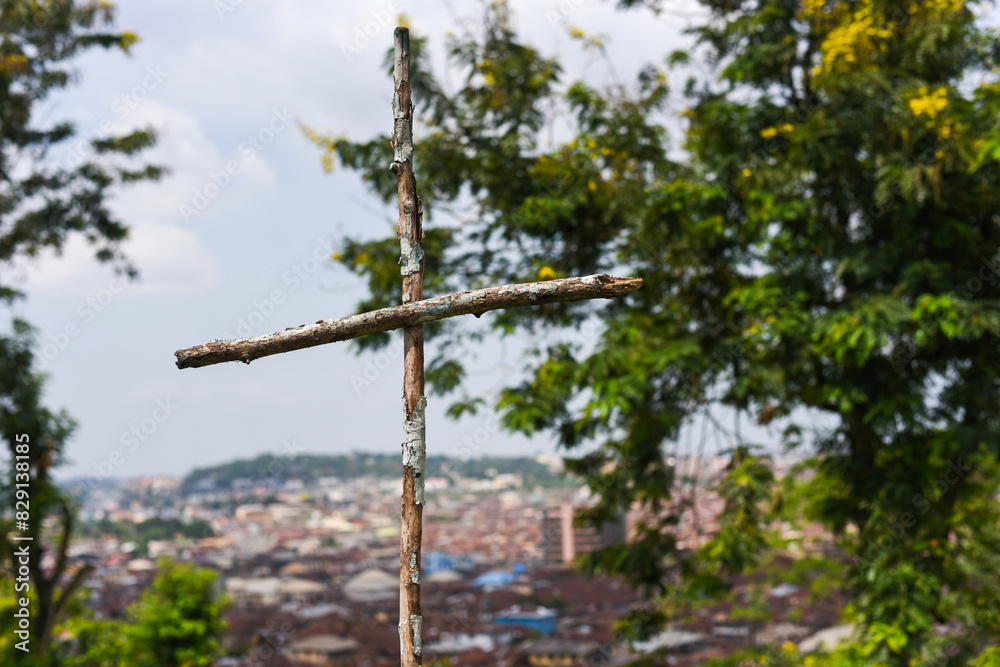 Ibadan, Oyo, Nigeria - April 15, 2024: A wooden cross against the Ariel view of Ibadan city. Ibadan, Oyo, Nigeria - April 15, 2024: A wooden cross against the Ariel view of Ibadan city.