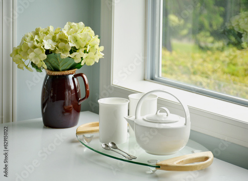 Flowers and tea for two beside window