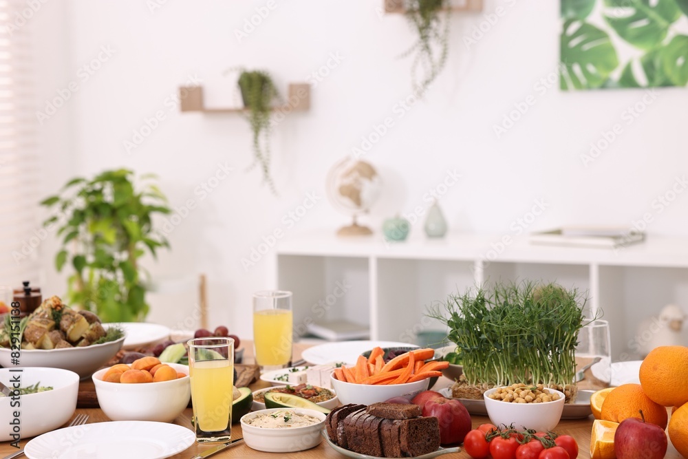 Healthy vegetarian food, glasses of juice and plates on table indoors Healthy vegetarian food, glasses of juice and plates on table indoors