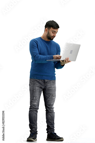A man, full-length, on a white background, uses a laptop © Katsiaryna