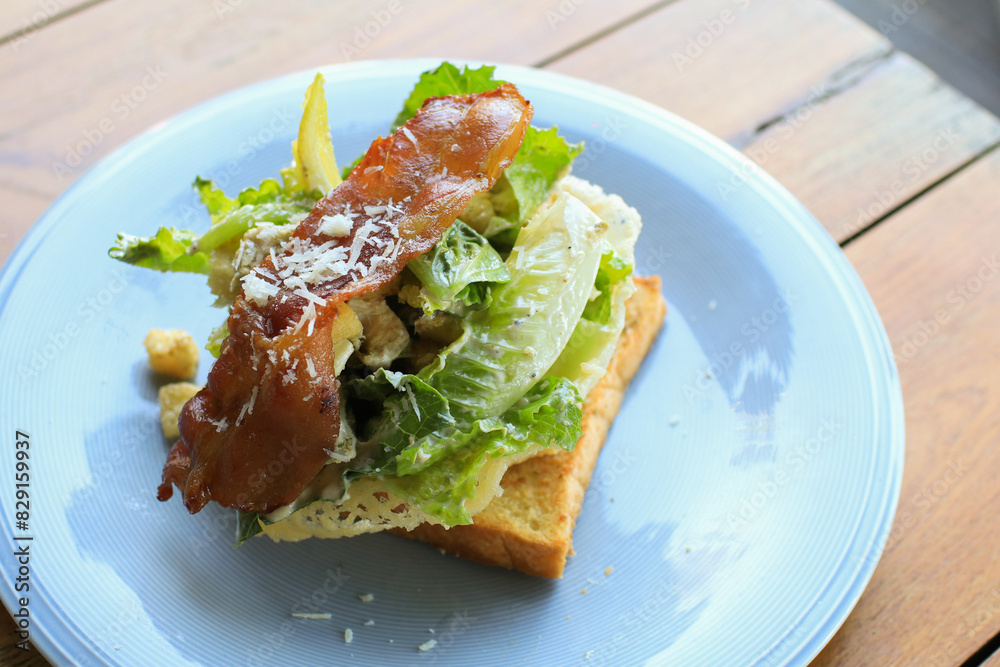 Sandwich for breakfast with cheese, bacon, tomatoes, cucumbers and lettuce in white plate. Healthy food lifestyle.  