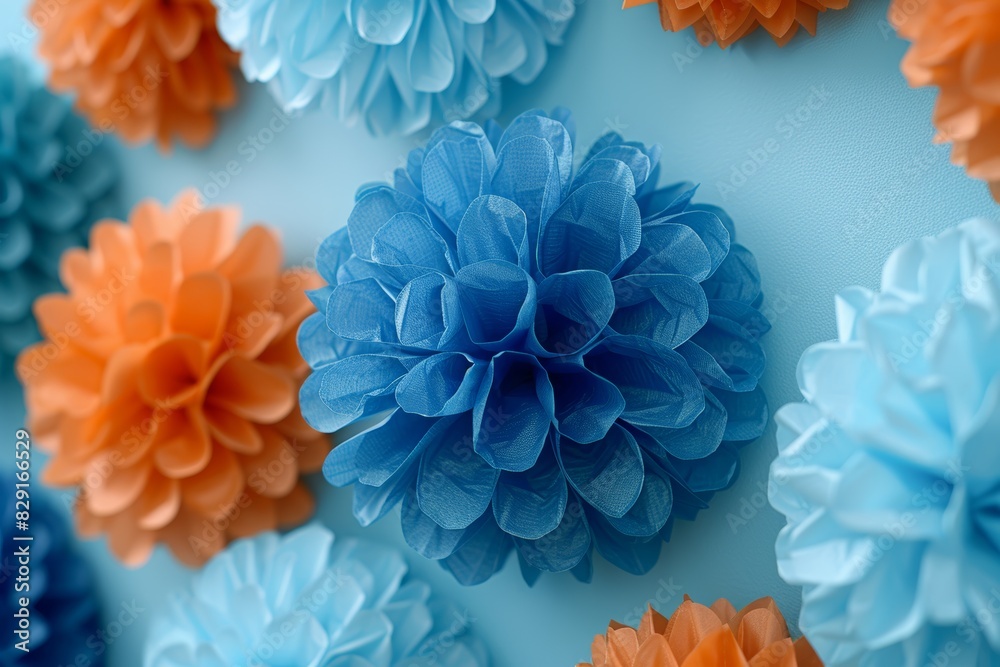 Beautifully Arranged Blue and Orange Paper Flower Decorations on a Soft Blue Background Capturing the Essence of Artistic Craftsmanship