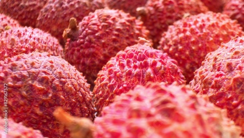 A vibrant close-up showcases lychee fruits, their spiky red shells bursting with texture and color. Each detail accentuates their tropical allure, inviting you to savor their exotic charm.
