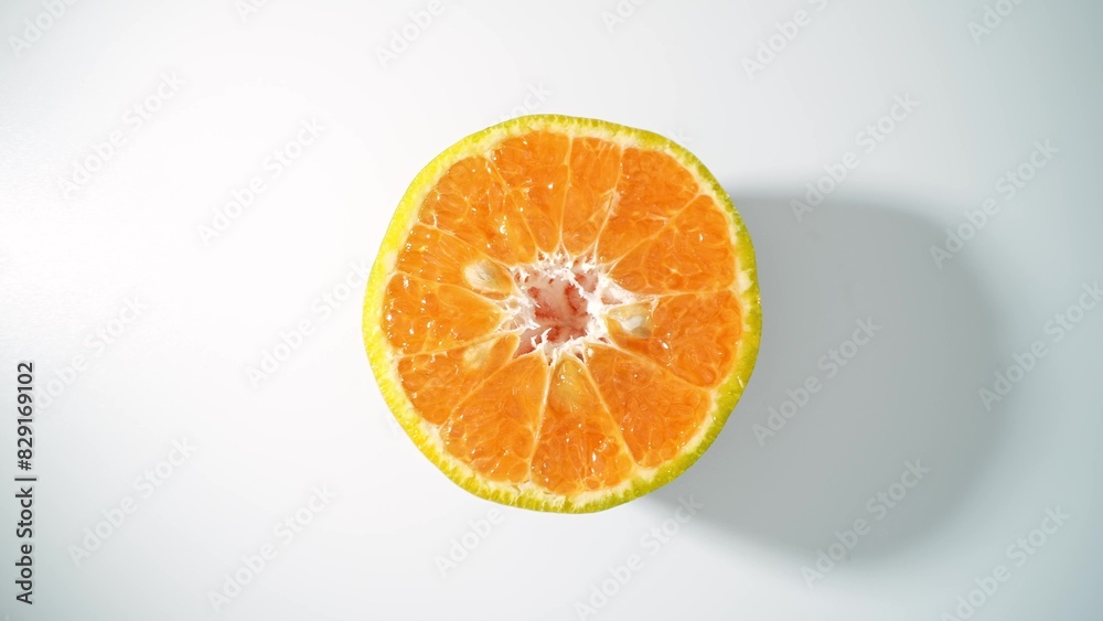 Fototapeta premium The glistening surface of this succulent orange half radiates a golden hue, its segments brimming with citrusy zest, a promise of tangy refreshment. Orange background.